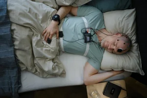 Man completing a sleep home study in bed for sleep apnoea assessment